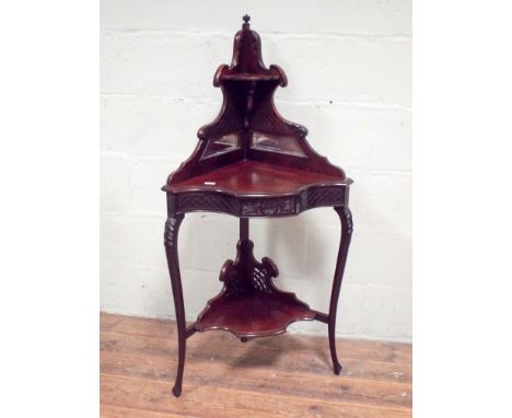 A two tier Edwardian mahogany corner table with shaped front and decorative back with mirrors and shelf, 61cms width, 140cms 