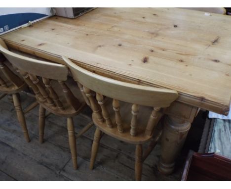 A large antique pine farmhouse dining table on turned legs together with six matching stick back Windsor chairs, the table is