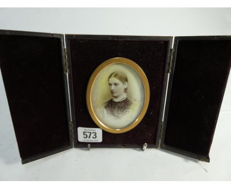 A Victorian portrait photograph mounted on a porcelain panel in a folding leather frame 
