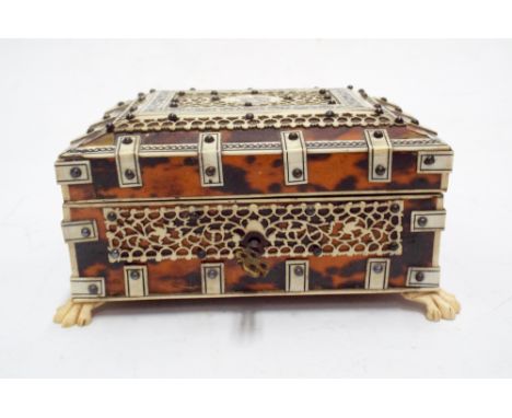 19th century tortoiseshell and bone overlaid box, the slightly domed lid with carved panel depicting a wolf. Raised on claw f