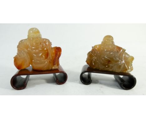 Two Chinese carved agate seated Buddha's on hardwood scroll type bases 9cms across