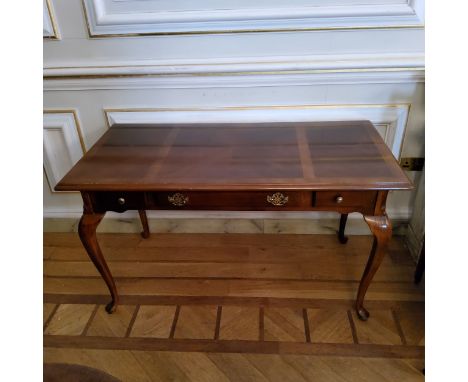 A Regency design mahogany sofa table with a quarter veneered surface, three drawers to frieze, raised on slender cabriole leg