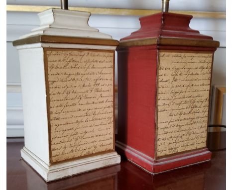 A pair of ceramic table lamps of squat column form, one red and gilt the other cream, the front panels mounted with a 'handwr