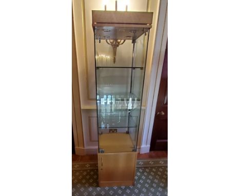 A contemporary locking glazed display unit, enclosing three glass shelves on a beech veneered cupboard/base (no key), 4 integ