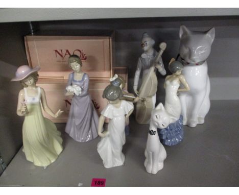 A group of Nao figures to include a clown playing a cello and two models of cats