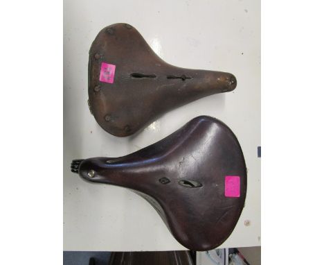 A Lepper vintage leather bicycle seat and a vintage Brooks leather bicycle seat with a Lucas bicycle bell