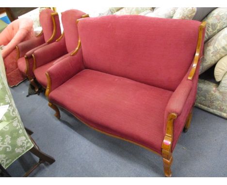 An Edwardian inlaid walnut three piece salon suite, upholstered in red fabric, inlaid floral and string decoration on French 