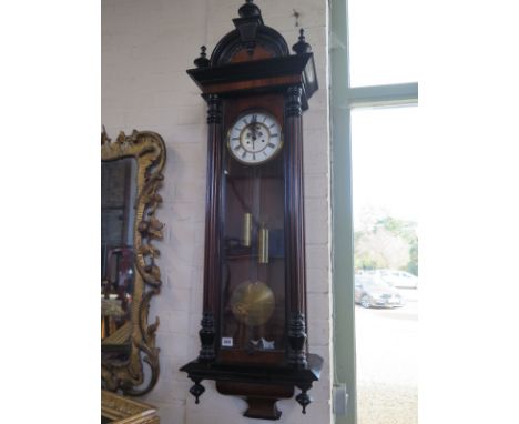 A double weight Vienna wall clock, with a walnut and ebonised case and a porcelain dial with open escapements, 130cm H 