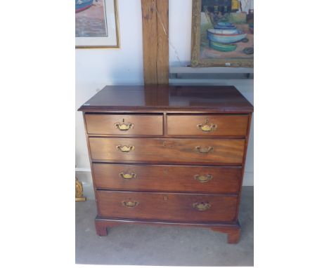 A Georgian mahogany chest with two short over three long drawers, with brass handles and oak lined drawers on bracket feet - 