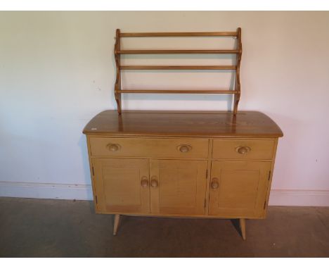 An Ercol blonde Elm sideboard with two drawers and three cupboard doors - 83cm H x 124cm x 45cm - and an Ercol wall shelf - 5