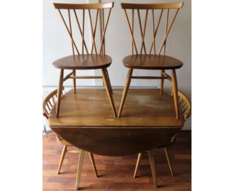 Ercol mid 20th century light oak dropleaf dining table with four stick back chairs. Table Approx. 72cm H x 113cm W x 124cm D
