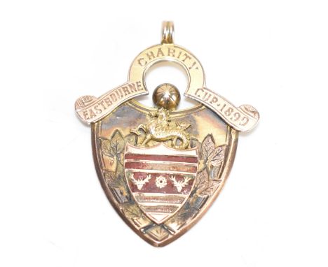 A Victorian 9ct gold medal fob, by Vaughton & Burney, of shield form with suspension loop, enamelled with a heraldic crest an