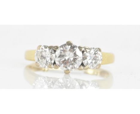 A diamond 18ct gold three-stone engagement ring, claw-set with a central brilliant-cut diamond measuring approximately 5.9mm 