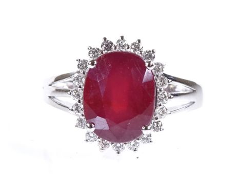 A 14ct white gold ruby and diamond cluster ring, oval-cut ruby approx 4.72ct, total diamond content approx 0.4ct, setting hei