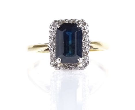 An 18ct gold sapphire and diamond cluster ring, emerald-cut sapphire approx 1.3ct, setting height 10.1mm, size K, 2.5g 