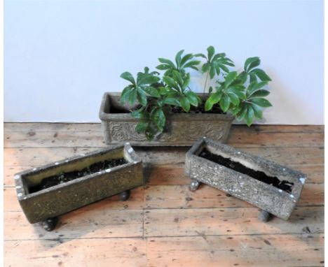 AN ORNATE WEATHERED GARDEN TROUGH AND TWO SMALLER TROUGHS, planted with Hellebore 