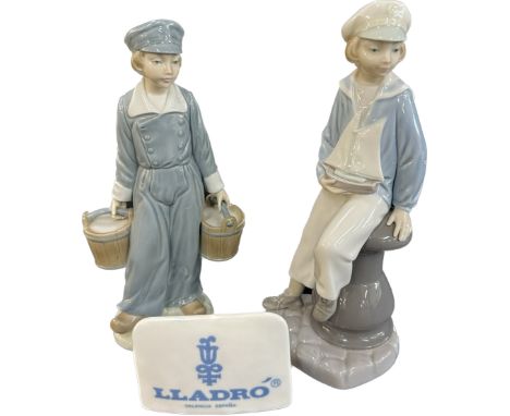 Two vintage Lladro figures a boy with two buckets, a boy with a toy ship and Lladro plaque, tallest measures approximately 9.