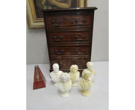 A modern mahogany finished four drawer chest, a metronome and four plaster busts 