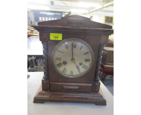 An early 20th century oak mantle clock having an 8 day movement and a silvered dial 