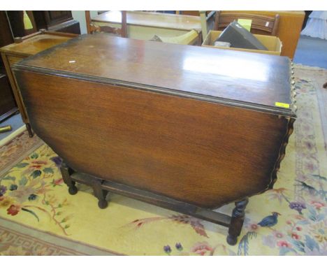 A 1930s oak gate leg dining table having barley twist supports, 29" h x 42"w 
