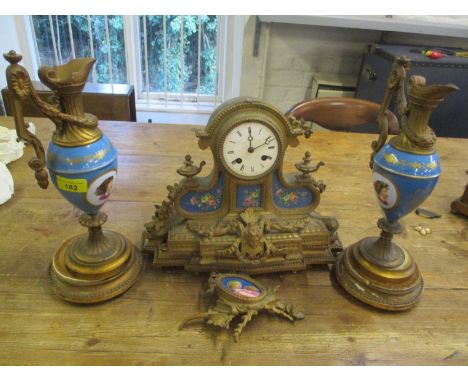 A late 19th century French mantle clock with two matching garnitures 