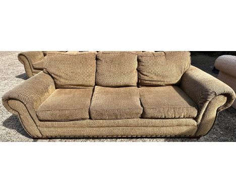 A brown and black flecked three seater sofa along with matching two seater and an arm chair