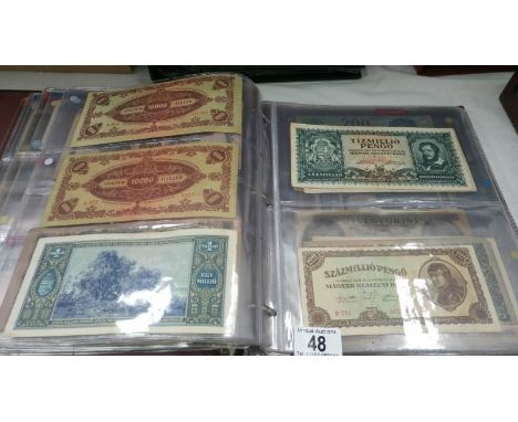 A folder of approximately 100 world bank notes, countries G - K