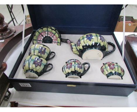 A cased Moorcroft tea for two set comprising teapot, sugar bowl, milk jug, 2 teacups and 2 saucers