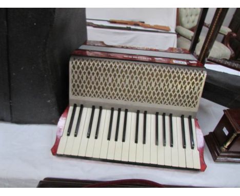 A cased Hohner piano accordion with old music