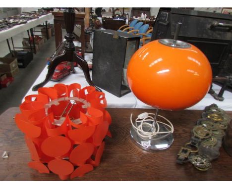 A retro orange lamp on chrome base and a retro orange shade