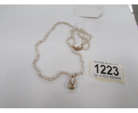 A pearl necklace with 18ct gold clasp and pendant drop