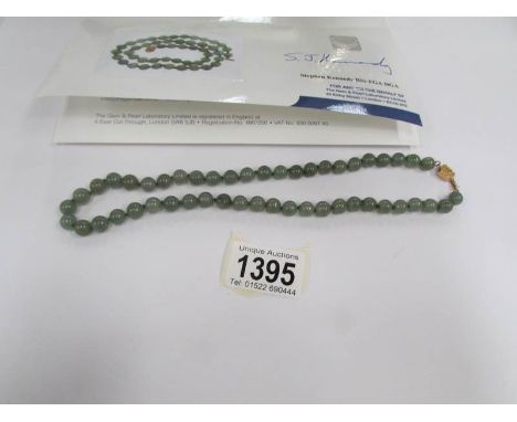 A Chinese grade A apple green jadeite jade necklace with 49 slightly graduated polished round stones, Largest 9 mm, smallest 