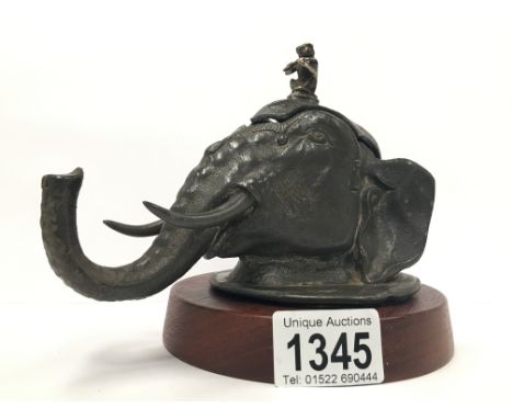 A circa 19th/20th century inkwell in the form of an elephant head with musician monkey finial