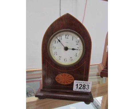 A mahogany inlaid arched top mantel clock