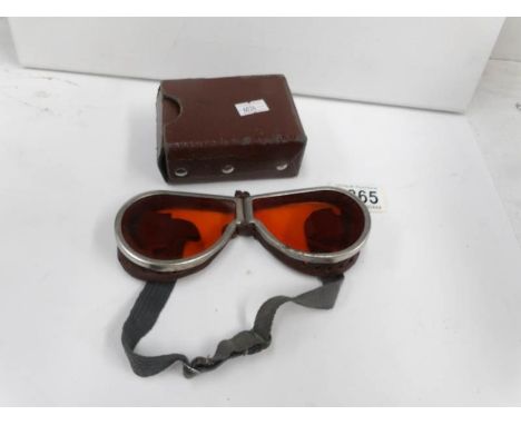 A pair of vintage motorcycle goggles and case