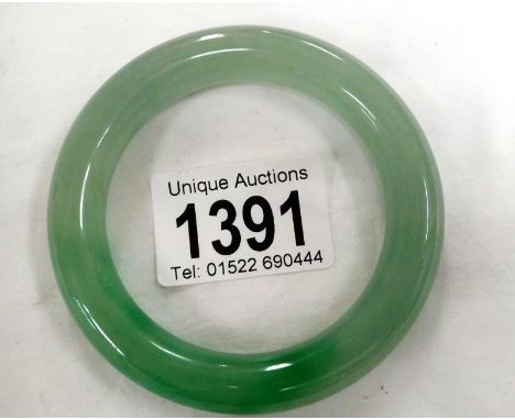 A Chinese apple green with dark green inclusions jadeite bangle