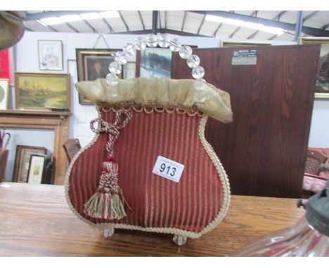 A vintage table lamp in the shape of a hand bag