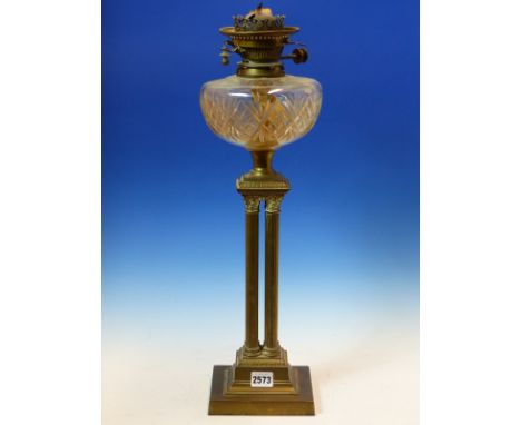 AN OIL LAMP WITH CUT GLASS RECEIVER SUPPORTED ON  ON FOUR BRASS CORINTHIAN COLUMNS AND STEPPED SQUARE FOOT.  H 57cms.