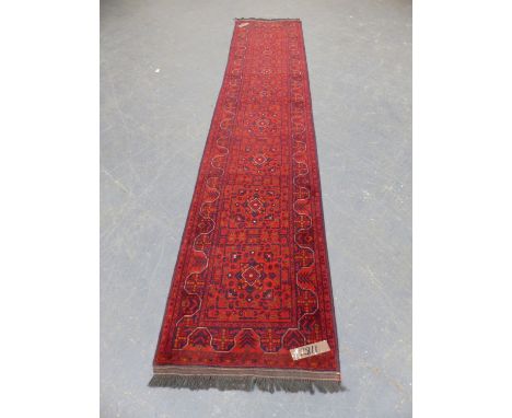 AN AFGHAN BELOUCH RUNNER.  373 x 82cms.