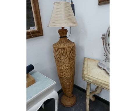 A BASKET WORK STANDARD LAMP, THE SHOULDERED OVOID BODY ON FLARED FOOT.   H 107cms.