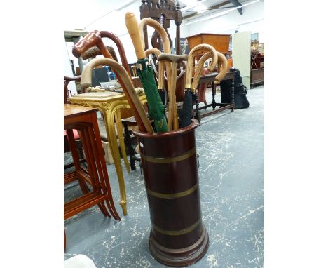 A MAHOGANY AND BRASS BOUND STICK STAND AND A QUANTITY OF WALKING STICKS, ETC.