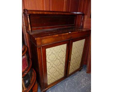 A REGENCY ROSEWOOD SIDE CABINET, THE RECTANGULAR TOP WITH REAR RECESSED SHELF, THE DAMASK INSET DOORS BELOW IN REEL TURNED FR