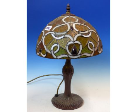 A TIFFANY STYLE TABLE LAMP WITH METAL BASE AND LEADED GLASS SHADE.   H 47cms.