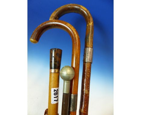 A WALKING CANE MOUNTED WITH A 9CT GOLD BAND, TWO WALKING STICKS WITH SILVER BANDS AND A SWAGGER STICK FROM THE SEAFORTH HIGHL
