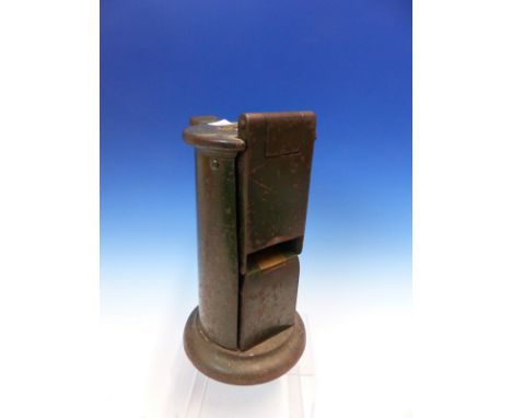 A GREEN PAINTED IRON TICKET DISPENSER, THE FLATTENED SIDE OF THE CYLINDRICAL SHAPE WITH THE MECHANICAL APPARATUS.   H 25cms.