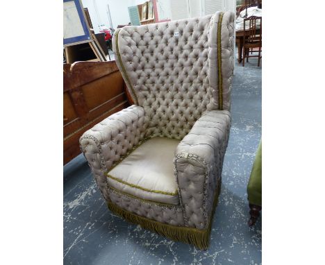 AN UNUSUAL BUTTON SILK UPHOLSTERED WING BACK ARMCHAIR.