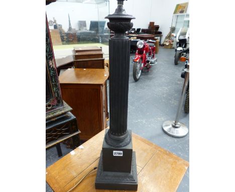 A BRONZE FLUTED COLUMN TABLE LAMP CAST WITH A BAND OF LEAVES ABOVE THE SQUARE FOOT.   H 63cms.