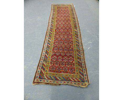 AN ANTIQUE TRIBAL CAUCASIAN RUNNER.  356 x 103cms.