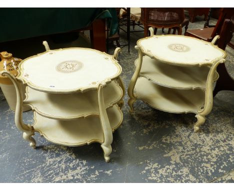A PAIR OF CREAM AND GILT DECORATED ITALIANATE THREE TIER LAMP TABLES.