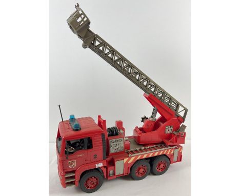 A 1:16th scale red hard plastic Man T6 410A fire engine by Bruder. With tipping and extending ladder. Moving parts throughout